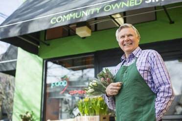 Älterer männlicher Florist steht vor einem Blumenladen - CAVF33216