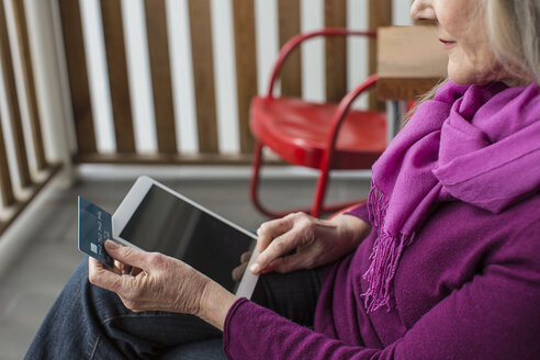 Hohe Winkel Ansicht der älteren Frau Online-Shopping beim Sitzen auf Stuhl auf der Veranda - CAVF33225