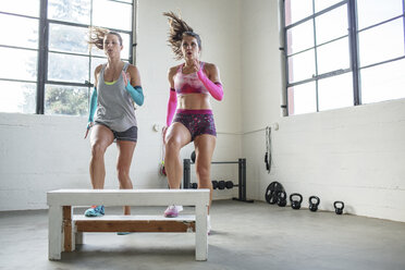 Weibliche Athleten trainieren auf einem Holzsitz im Fitnessstudio - CAVF33265