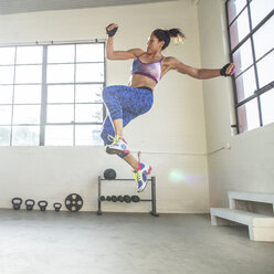 Selbstbewusster Sportler in voller Länge beim Training im Fitnessstudio - CAVF33269