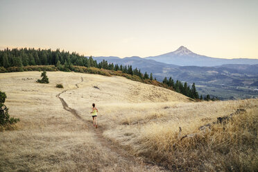 High angle view of woman jogging on mountain against clear sky during sunset - CAVF33329