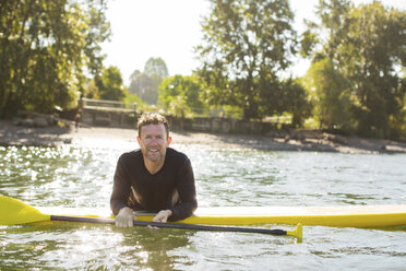 Porträt eines lächelnden Mannes beim Paddeln auf einem Fluss - CAVF33355