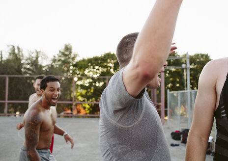 Glückliche Freunde schreien beim Basketballspielen auf dem Platz - CAVF33372