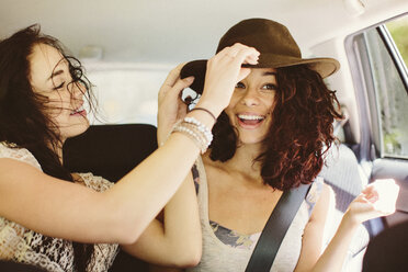 Happy female friends traveling in car - CAVF33448