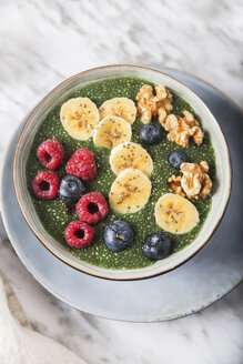 Buddha bowl of green chia pudding with slices of banana, blueberries, raspberries and walnuts - RTBF01140