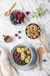 Buddha bowl of green chia pudding with slices of banana, blueberries, raspberries and walnuts - RTBF01141