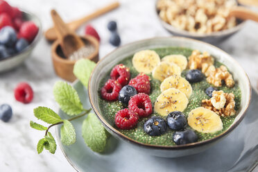 Buddha-Schale mit grünem Chia-Pudding mit Bananenscheiben, Heidelbeeren, Himbeeren und Walnüssen - RTBF01142