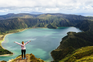 Azores, Sao Miguel, Woman with raised arms on the top of the Lagoa do Fogo - KIJF01917