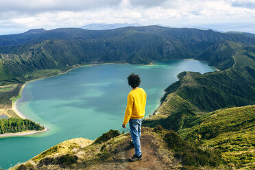 Azores, Sao Miguel, rear view of man looking at the Lagoa do Fogo - KIJF01919