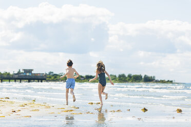 Mädchen und Junge laufen am Strand - FOLF06715