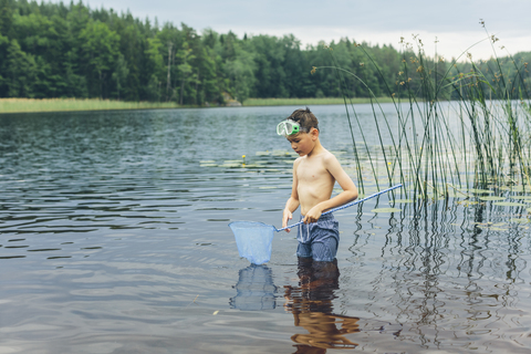 Junge watet und angelt, lizenzfreies Stockfoto