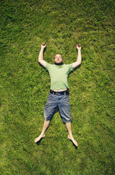 Mann im Gras liegend im Sommer - FOLF06795