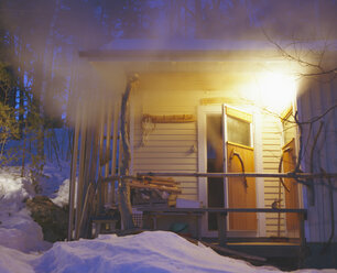 Steam flowing out of ajar door of Finnish sauna building - FOLF06834