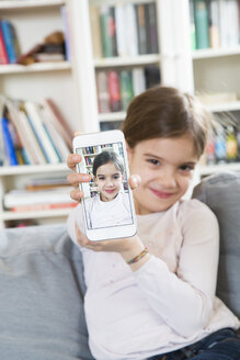 Lächelndes Mädchen zeigt Selfie auf Handy-Display - LVF06850