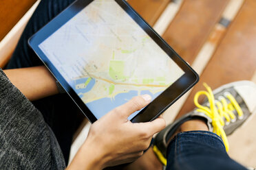 Nahaufnahme einer Frau, die ein Tablet mit einer digitalen Straßenkarte hält - VABF01525