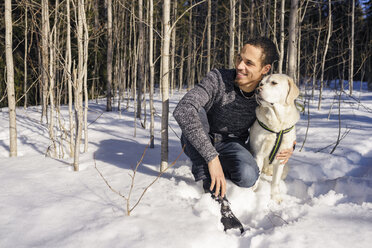 Mann kniend mit Hund im Schnee - FOLF06846