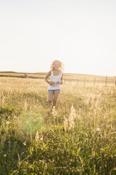 Teenage girl running through meadow - FOLF06853