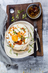 Fladenbrot mit Knoblauchjoghurt, Spiegelei und Chilibutter auf Schneidebrett - SBDF03508