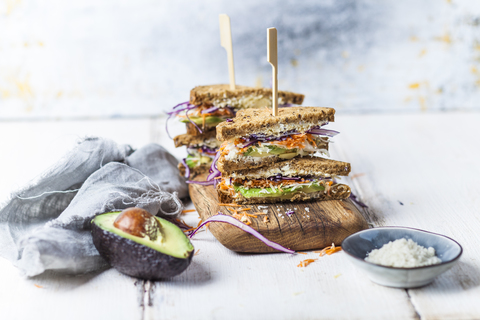 Veggie-Sandwich, Vollkorntoastbrot mit geriebener Karotte, Rotkohl, Weißkohl, Avocado und Käse, lizenzfreies Stockfoto