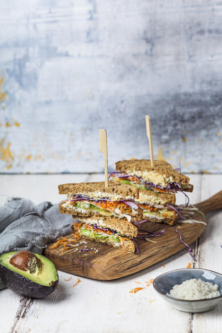 Veggie-Sandwich, Vollkorntoastbrot mit geriebener Karotte, Rotkohl, Weißkohl, Avocado und Käse, lizenzfreies Stockfoto