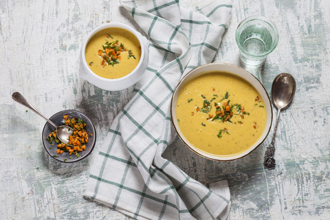 Schalen mit veganer Karottencremesuppe mit Kokosmilch, lizenzfreies Stockfoto