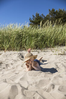 Junge mit Strohhut am Strand liegend - FOLF06978