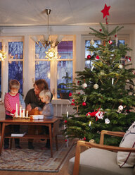 Woman and boys at table by christmas tree - FOLF07003