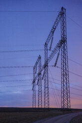 Electricity pylons against dramatic sky at sunset - FOLF07165