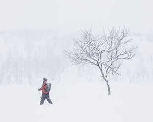 Frau geht mit Wanderstöcken durch den Schnee - FOLF07170