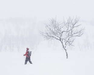 Woman walking through snow with hiking poles - FOLF07170