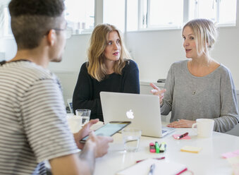 Three professionals talking at desk - FOLF07262