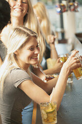 Blonde Frauen trinken Bier in einer Bar - FOLF07276