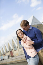 Smiling young couple against buildings - FOLF07293