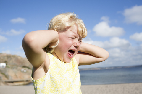 Schreiendes Mädchen am Strand, lizenzfreies Stockfoto