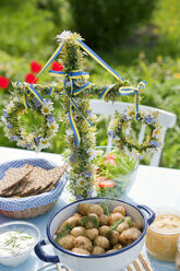 Frische Kartoffeln und Hering im Glas auf einem mit Blumenkränzen geschmückten Tisch - FOLF07470