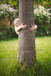 Mädchen versteckt sich hinter Baum - FOLF07480