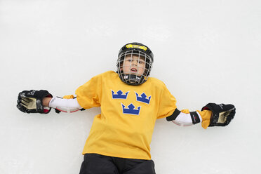 Junger männlicher Eishockeyspieler auf dem Eis liegend - FOLF07509
