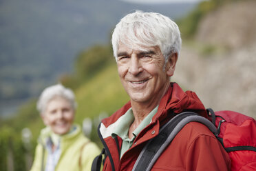 Porträt eines lächelnden älteren Mannes mit Rucksack - RORF01251