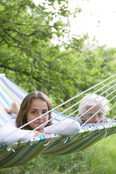 Girl and boy lying on hammock - FOLF07557