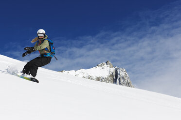 Junge Frau beim Snowboarden in den Alpen - FOLF07592