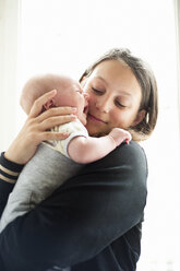 Teenage girl holding little baby sister crying - FOLF07626