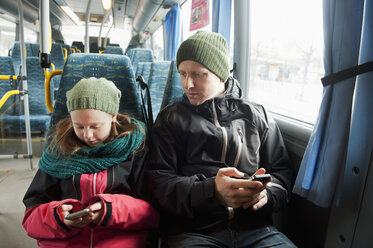 Mädchen mit Vater sitzt in der Straßenbahn und benutzt Smartphones - FOLF07752