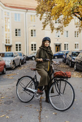 Junge Frau stehend mit Fahrrad - FOLF07759