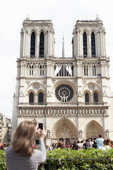 Young woman photographing Notre Dame Cathedral - FOLF07878