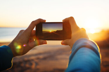 Woman's hands photographing sunset - CAVF33518