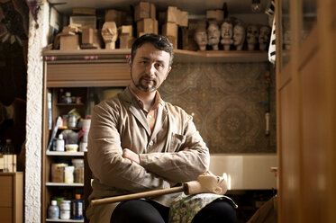 Portrait of confident craftsman sitting in workshop - CAVF33553