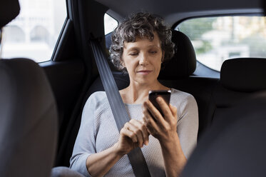 Reife Frau telefoniert während der Fahrt im Auto - CAVF33571