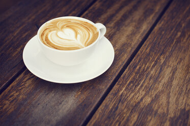 Close-up of coffee latte on wooden table at cafe - CAVF33579
