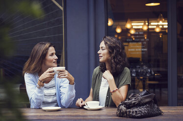 Freundinnen unterhalten sich bei einem Kaffee in einem Straßencafé - CAVF33581