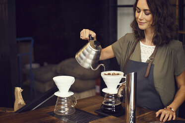 Weibliche Barista bereitet Kaffee in einem Café zu - CAVF33587